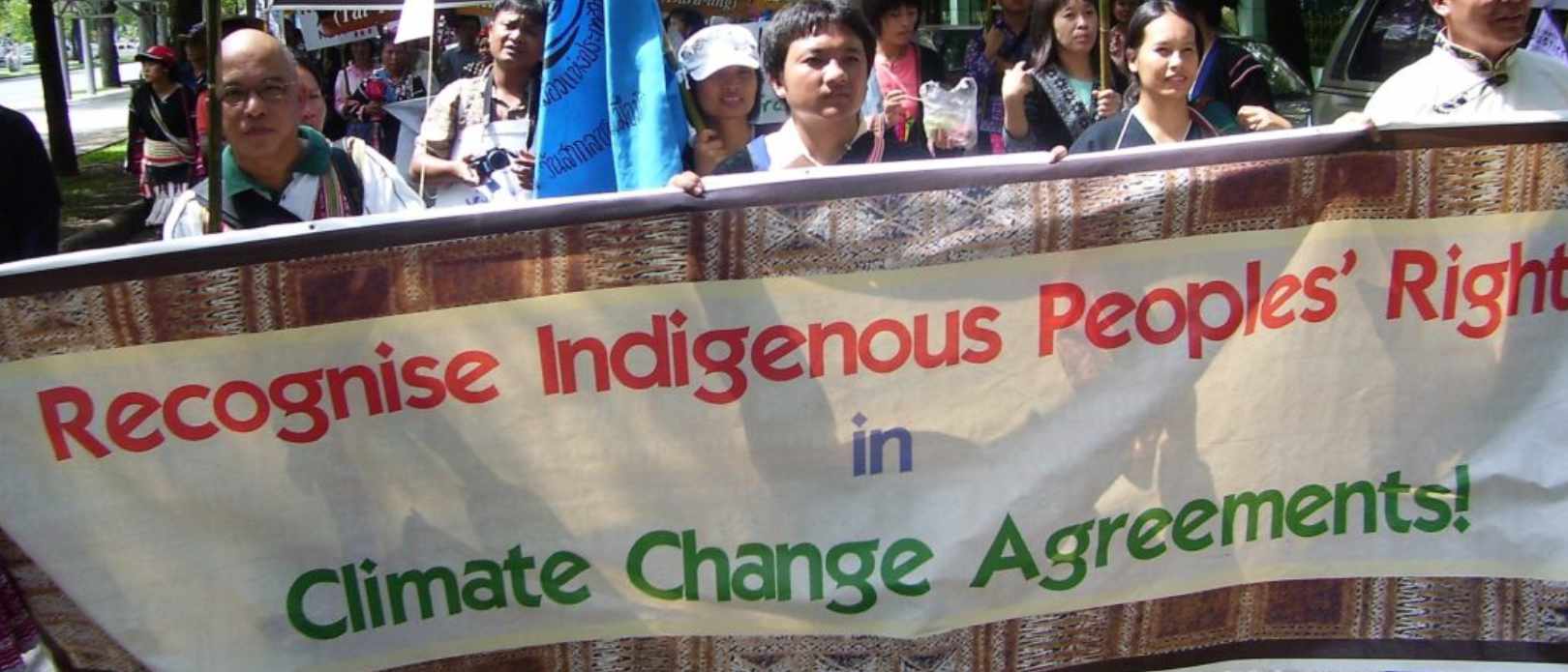 People demonstrating against climate change in Bangkok in 2009, holding a banner saying "Recognise Indigenous Peoples' Rights in Climate Change Agreements".